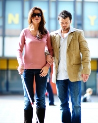 chica ciega con bastón y gafas y su acompañante