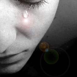 Emoción tristeza, detalle de una cara triste con una lágrima iluminada