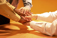 Grupo de personas juntando sun manos en los organismos de apoyo al emprendedor