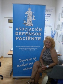 presidenta asociación defensor del paciente carmen flores delante de cartel de la asociación