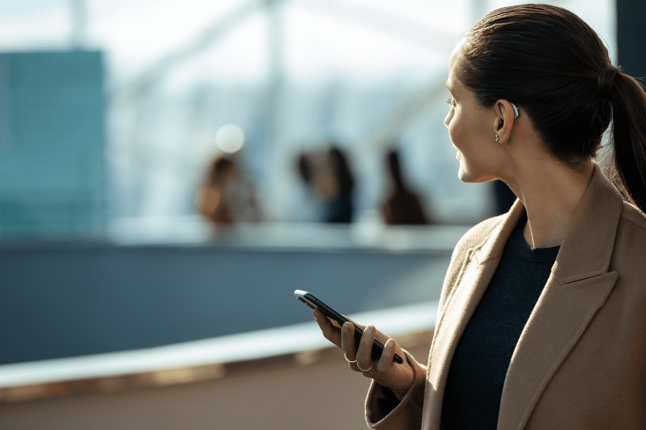 chica con audífonos en el puerto escuchando música con su móvil