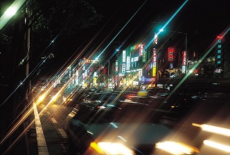 Calle iluminada y vehículos. Calentamiento global