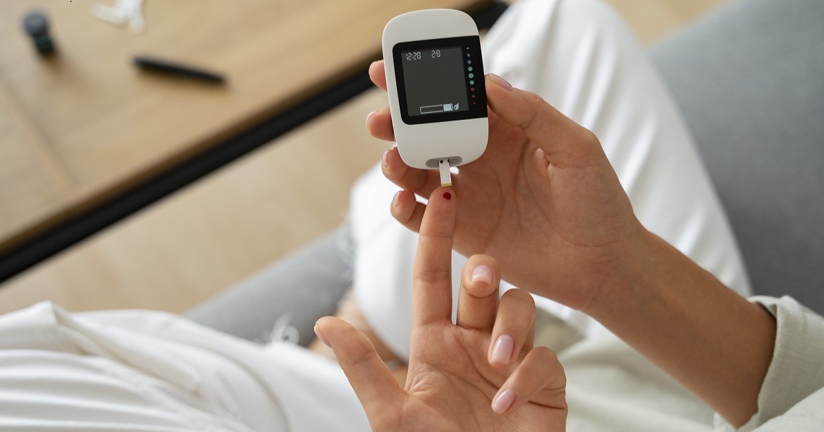 Mujer con la enfermedad encodrina de la diabetes comprobando su nivel de glucosa.