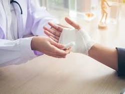 Un médico venda una mano a una persona por un accidente laboral