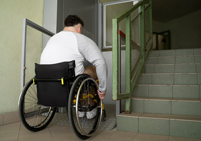 chico subiendo en un elevador con su silla de ruedas