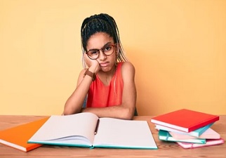 Una joven estudiando y con cara de asco