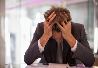 Una persona con dolor de cabeza en el trabajo