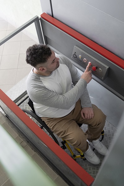 persona con silla de ruedas usando un salvaescaleras