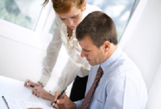 Dos trabajadores mirando una documentación (Fotolia). Oficina de atención a la discapacidad