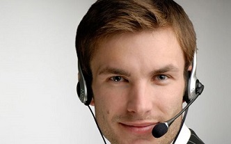 Joven teleoperador co con auriculares en su trabajo, que debe regular volumen para evitar érdida de audición