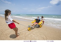 Personal de la Cruz Roja usando la silla anfibia de la playa Norte de Gandia. Fotografía de Àlex Oltra.