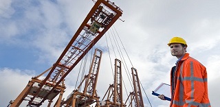 Prevención de riesgos laborales, un trabajador protegido en un edificio con grúas