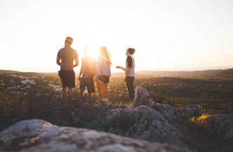 Tres jóvenes viendo amanecer el sol