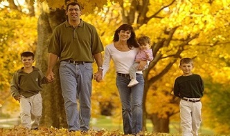 Tratamiento fiscal de la discapacidad, una familia con sus tres hijos paseando por un campo
