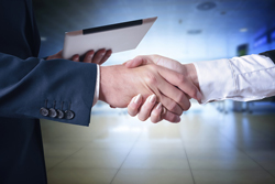 Dos personas dándose la mano en señal de acuerdo