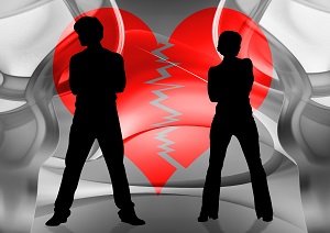 Silueta de una pareja separada y entre ellos un corazón partido por la mitad