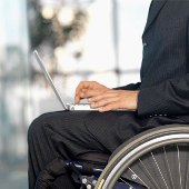 Persona con portátil en silla de rueda con expectativas de futuro