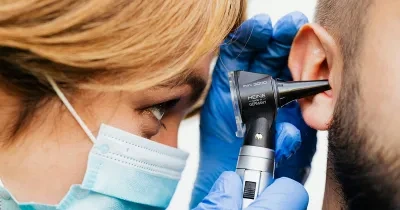 Doctora realizando una revisión auditiva a un paciente
