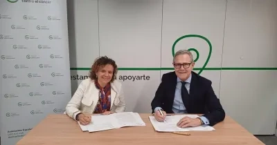 firma del acuerdo con los representantes de las dos entidades en la sala de reuniones de la AECC