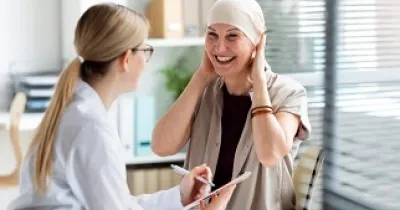 Una mujer bajo los efectos del tratamiento contra el cáncer de mama atendida por una profesional (Fuente: Doctoralia)