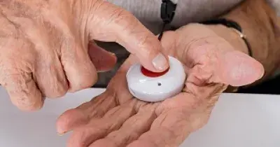 Una persona mayor con un botón rojo de teleasistencia (Fuente: CAM)