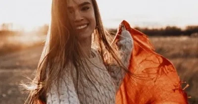 mujer con una puesta de sol al fondo