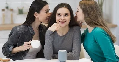 mujeres jovenes hablando al oido a otra mujer sorda