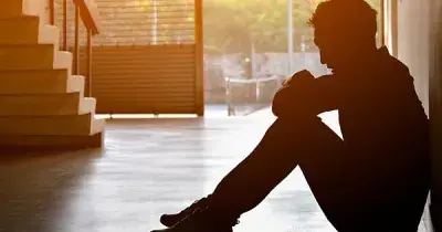 Una persona joven sentada en el suelo con depresión (Fuente: SHUTTERSTOCK)