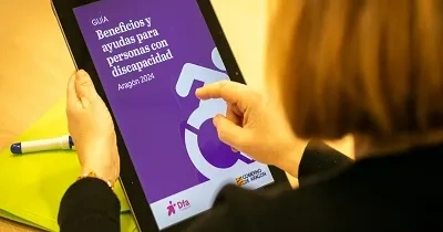 Una persona viendo online, en una tablet, la guía sobre beneficios y ayudas para personas con discapacidad de la Fundación Dfa (Fuente: Fundación Dfa)