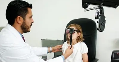 Doctor revisando a una niña los ojos