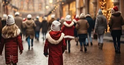 Una niña pasea por la calle de una ciudad en plena Navidad, junto a más gente (Fuente: 123RF/itchaznong)