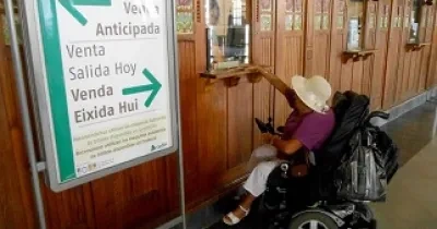 Una mujer usuaria de silla de ruedas adquiere un billete en las taquillas de la Estación del Norte de Valencia (Fuente: Cocemfecv)