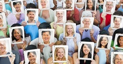 grupos de personas mostrando fotografías de caras sonrientes