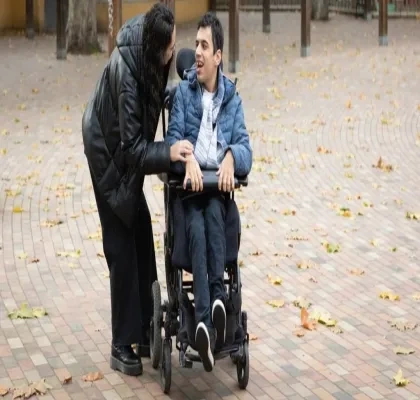 Una persona en silla de ruedas es asistida por otra