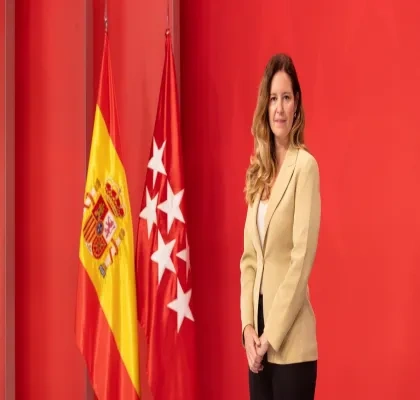 Ana Dávila junto a las banderas de españa y la comunidad de Madrid