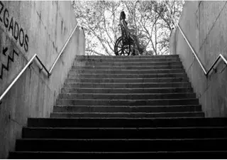 Mujer en silla ruedas que no puede bajar a los juzgados debido a las escaleras