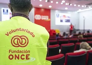 Voluntario de la ONCE de espaldas, mirando hacía el evento de Fundación Once