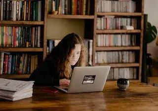 niña en biblioteca estudiando