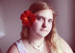 chica con discapacidad intelectual con una flor en el pelo