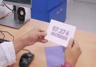 manos cogiendo una tarjeta morada que pone, 57.274 mujeres