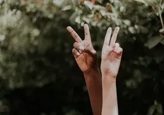dos manos mostrando dos dedos en forma de V, por los derechos humanos