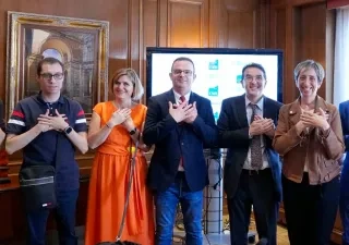 Voluntarios de la ONCE hacen el signo del voluntariado, cruzando las mano sobre el pecho