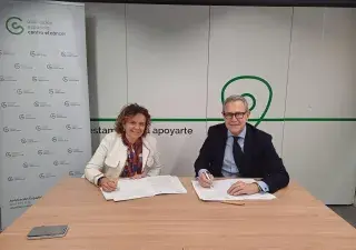 firma del acuerdo con los representantes de las dos entidades en la sala de reuniones de la AECC