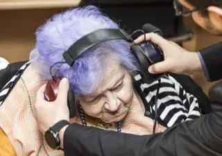 señora mayor probando su audición con unos auriculares