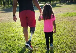 Un padre con discapacidad física pasea con su hija por el parque (Fuente: Servimedia)