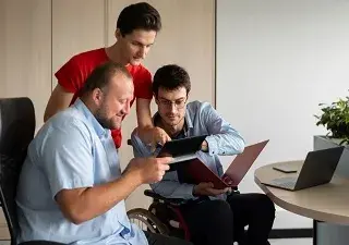 Lectores con discapacidad consultando biblioteca (Fuente: Servimedia)
