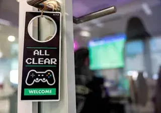 Detalle de un cartel colgado en una puerta de una zona de gamming