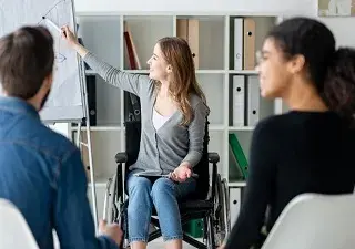 Una persona con discapacidad y en silla de ruedas, en una reunión de trabajo (Fuente: Servimedia)