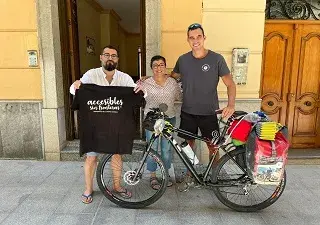 Foto de tres personas y una bici mostrando una camiseta que dice, accesibles 