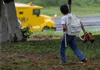 Fotografía de un niño latinoamericano que va a la escuela descalzo por el campo, para el banner de la iniciativa 'Piecitos Colorados' de la Fundación Prosegur